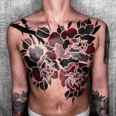 a man with tattoos on his chest is looking up at the sky and has flowers painted on his chest