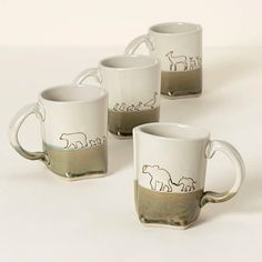 three mugs with animals drawn on them sitting next to each other in front of a white background