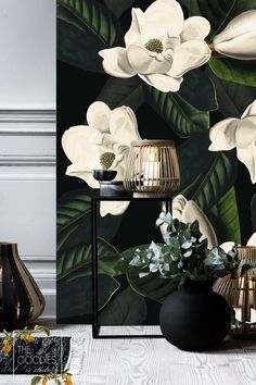 the wallpaper is decorated with white flowers and green leaves, along with black vases