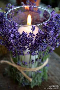 a candle that is sitting in a glass vase with lavenders on it and the words crea bonitos portavelasa o comparitar