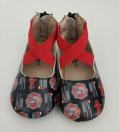 a pair of baby shoes with fire department print on them, tied to each other