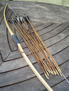 an arrow and some arrows on top of a wooden table