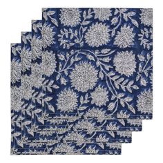 four blue and white napkins with flowers on them