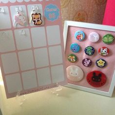 there are many buttons in the frame on the table next to the magnets that have been placed on them