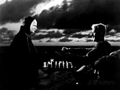 two men are playing chess in front of the sky and clouds, one is wearing a nun costume