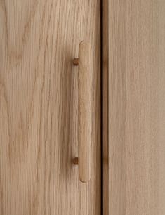 a close up of a wooden cabinet door with a handle on the left and right side