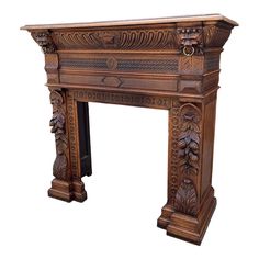 an ornate wooden fireplace mantel with carvings on the top and sides, in brown wood