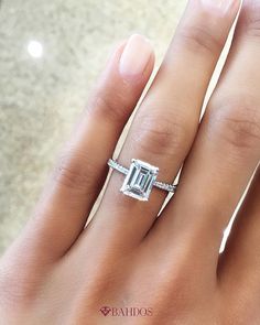 a woman's hand with a ring on it and an emerald stone in the middle