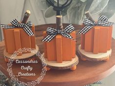 three wooden blocks with bows on them sitting on top of a wood table next to a candle holder