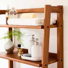 a wooden shelf with soap, lotion and towels on it