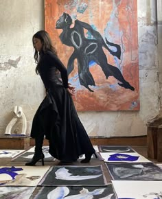 a woman standing in front of an art work on the ground with her hands behind her back