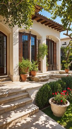 a house with steps leading up to it and potted plants in the front yard