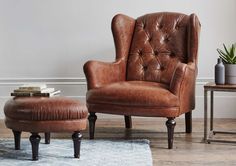 a brown leather chair and ottoman in a living room