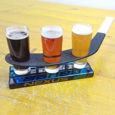 three glasses of beer sit on top of a skateboard