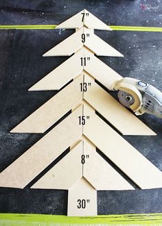 a cut out christmas tree sitting on top of a table next to a pair of scissors