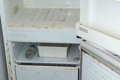 an old refrigerator with the door open and water bottle in it's bottom drawer