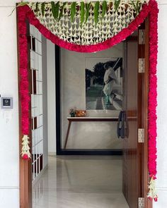 an entrance to a room decorated with pink and white flowers