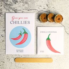 two donuts are next to a book about chillies and a rolling pin on the ground