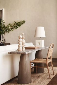 a table with two chairs and a lamp on top of it in a living room