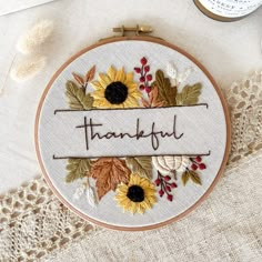 a hand embroidered hoop with the words, thank you and sunflowers on it