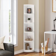 a living room filled with furniture and a white book shelf next to a window on top of a hard wood floor