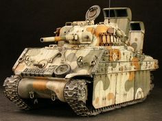 a toy tank with camouflage paint on it's body and turrets is shown in front of a black background