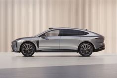 an electric car is shown in front of a beige wall and grey floor with vertical blinds