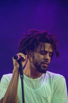 a man with dreadlocks holding a microphone