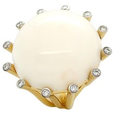 A lustrous white coral embodies the warmth of 18k yellow gold and diamonds for this La Luna ring. Secured by narrow cylinders of 18k yellow gold, the ring features a round 25mm carving of white coral with a single brilliant cut diamond on each tip. A multi-split shank forms as the cylinders join. The total weight is 0.29 carats of brilliant cut diamonds and 54.14 carats of white coral. Measurements for the ring are 1.25 inches (width) by 1.25 inches (length) by 0.5 inches (depth). White Coral, 18k Yellow Gold Ring, Domed Ring, Split Shank, Yellow Gold Ring, Brilliant Cut Diamond, Yellow Gold Rings, Gold Ring, The Ring