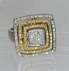 two tone gold and white diamond ring with square design on the center, surrounded by smaller yellow and white diamonds