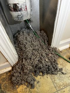 a pile of dirt sitting on the floor next to a door