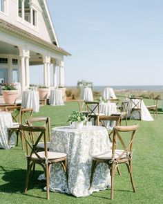 an outdoor dining area with chairs and tables set up on the lawn for a formal function