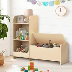 a child's book shelf with toys in it and a clock on the wall