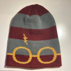 a knitted harry potter beanie hat with glasses and lightning bolt on the front