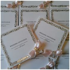 the wedding stationery is laid out on top of each other with ribbons and bows