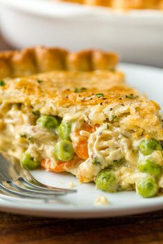 a slice of chicken pot pie on a white plate with a fork next to it