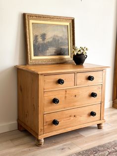 a wooden dresser with a painting on top