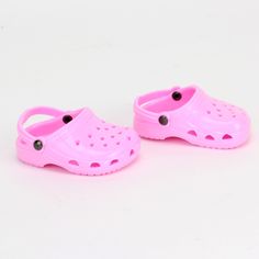 a pair of pink crocs sitting on top of a white table