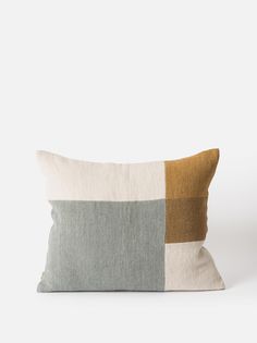 a pillow with two different colored squares on the front and one in grey, yellow and white