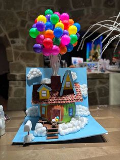 a paper house with balloons on the roof