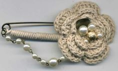 a crocheted brooch with pearls attached to it