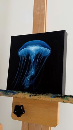 a painting of a blue jellyfish on an easel