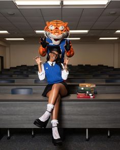 a woman sitting on top of a bench next to a stuffed animal tiger over her head