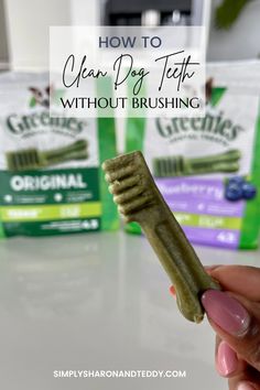 a person holding up a toothbrush in front of three bags of dental care products