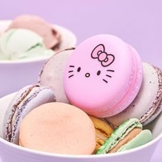 a bowl filled with macaroons and donuts covered in hello kitty frosting