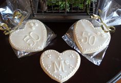 two heart shaped cookies sitting on top of plastic wrappers next to a potted plant