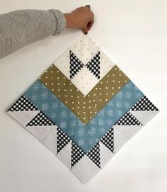 someone is holding up a piece of fabric to make an origami wall hanging