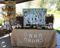 a table topped with cakes and cupcakes under a tent