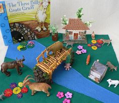 an assortment of toys and books on a green carpeted area with flowers, animals, and other items