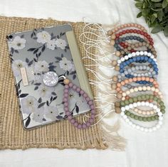 a bunch of bracelets sitting on top of a table next to an open book